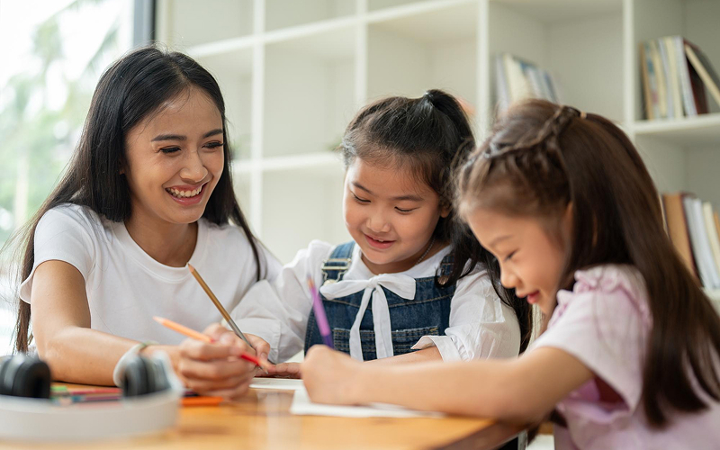 Teacher guiding students in a small after-school care class.