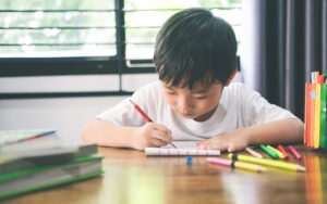 Young boy focused on learning activities at home.