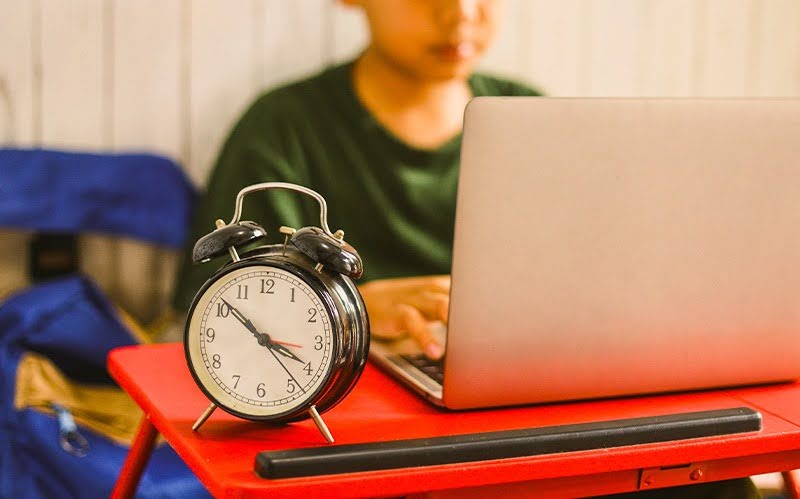 Student managing time on laptop in after-school care programme.